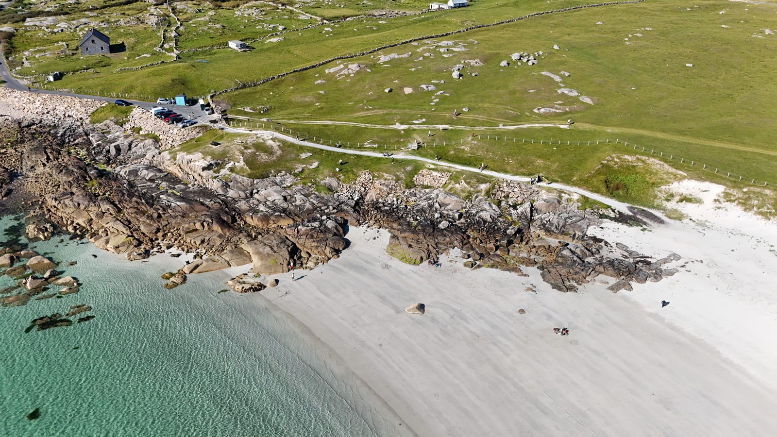 Aerial view of a rocky shore meeting white sand